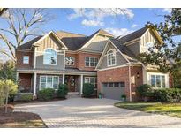 Beautiful two-story home with brick and gray siding, manicured landscaping, and a paved driveway at 2305 Flintwood Ln, Charlotte, NC 28226