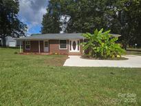 Charming brick home with a well-manicured lawn and a newly paved driveway at 245 College E Ave, Shelby, NC 28152