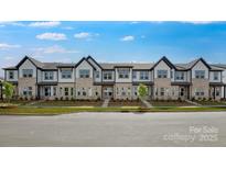 Modern townhome exterior showcasing brick and neutral siding, black trim, lush landscaping, and inviting curb appeal at 3105 Beacon Heights Rd, Indian Land, SC 29707