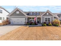 Charming single-Gathering home with a two-car garage, an American flag, and attractive landscaping at 3113 Winged Teal Ct, Belmont, NC 28012