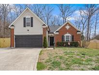 Charming home featuring a brick and siding exterior, an attached garage, and a well-manicured lawn at 4710 Nijinsky Ct, Charlotte, NC 28216