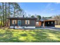 Charming one-story home with a landscaped yard, a carport, and newly painted exterior at 627 Westway Dr, Gastonia, NC 28054