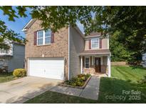 Charming two-story home featuring brick and neutral siding with a two-car garage and manicured landscaping at 6808 Wandering Creek Dr, Charlotte, NC 28216