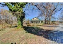 Charming single-Gathering home featuring a covered porch and spacious front yard surrounded by mature trees at 966 Marys Grove Rd, Cherryville, NC 28021