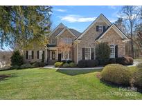 Beautiful two-story brick home featuring a manicured lawn and professional landscaping at 105 Elizabeth Brook Dr, Davidson, NC 28036