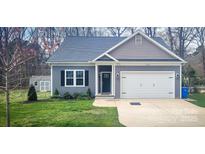 Charming home with well-maintained lawn, attached garage, and stylish curb appeal at 1123 Fieldstone Rd, Mooresville, NC 28115