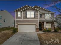 Charming two-story home featuring a two-car garage and welcoming front porch at 1411 Afternoon Sun Rd, Matthews, NC 28104