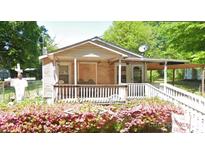 Charming single-story home featuring a cozy front porch and a colorful garden in the front yard at 318 Queens Ct, Gastonia, NC 28052