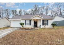 Charming single-story home with a well-manicured lawn and inviting front porch seating area at 3604 Oakwood Rd, Charlotte, NC 28269