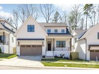 Charming two-story home featuring board and batten siding, a two-car garage, and professionally landscaped yard at 3949 Plainview Rd, Charlotte, NC 28208
