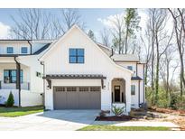 Modern farmhouse with two-car garage, board and batten siding, and covered front porch at 3953 Plainview Rd, Charlotte, NC 28208