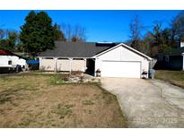 Charming single-story home featuring a covered porch, attached garage, and a spacious front yard at 4715 Cricklewood Ln, Charlotte, NC 28212