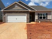 Charming single-story home featuring a stone-accented facade, two-car garage, and well-lit entryway at 5712 Skinny Ln, Charlotte, NC 28215