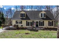 Charming home featuring dormer windows, a cozy front porch, and a wooden deck, perfect for outdoor enjoyment at 7648 Forest Oak Dr, Denver, NC 28037