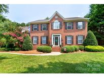 Charming two-story brick home featuring manicured landscaping, a welcoming entrance, and classic architectural details at 10625 Olde Irongate Ln, Mint Hill, NC 28227