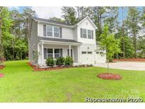 Charming two-story home featuring gray siding, black shutters, and a well-manicured lawn at 11032 Gary Player Dr # 961, Lancaster, SC 29720