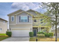 Inviting two-story home featuring a two-car garage and manicured landscaping at 1309 Afternoon Sun Rd, Matthews, NC 28104