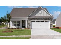 Charming single-story home with stone accents, white garage door, manicured lawn, and inviting entrance at 136 Adams Tree Way, Troutman, NC 28166