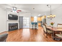 Open-concept living room featuring a fireplace, hardwood floors, and sliding door access to the outside at 16911 Commons Creek Dr, Charlotte, NC 28277