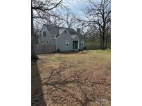 Charming two-story home with a gray exterior, mature trees, and a spacious front yard at 28714 Nc Hwy 24/27 Hwy, Albemarle, NC 28001