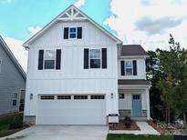 New construction two-story home with white siding, black shutters, garage, and a light blue front door at 29069 Low Country Ln # 602, Lancaster, SC 29720