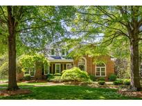 Charming brick home with mature trees, lush lawn, and manicured landscaping at 4340 Sequoia Red Ln, Charlotte, NC 28226