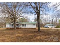 Charming single-story home with a metal roof, green shutters, and a detached garage at 5212 Old Concord Rd, Salisbury, NC 28146