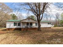 Charming single-story home features a welcoming porch and a large yard with mature trees at 5212 Old Concord Rd, Salisbury, NC 28146