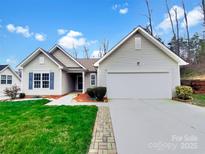 Charming single-story home featuring a well-manicured lawn, attached garage, and inviting front entrance at 5928 Briggs Dr, Charlotte, NC 28269