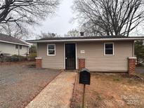 Charming tan home with a brick lined walkway and updated mailbox at 1224 Hollywood Ter, Albemarle, NC 28001