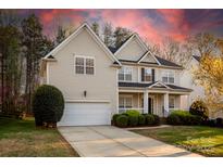 Inviting two-story home with a two-car garage, manicured lawn, and a charming front porch at 14333 Maclauren Ln, Huntersville, NC 28078