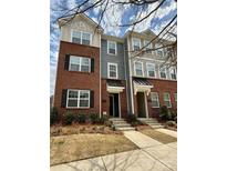 Stylish three-story townhome with brick and siding exterior, complemented by well-maintained landscaping at 16764 Summers Walk Blvd, Davidson, NC 28036