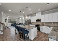 Modern kitchen with stainless steel appliances, a granite countertop island and hanging lights at 16764 Summers Walk Blvd, Davidson, NC 28036
