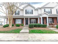 Traditional two-story townhome with brick and vinyl siding, black shutters, and a well-maintained front lawn at 2856 Summergrove Ct, Matthews, NC 28105