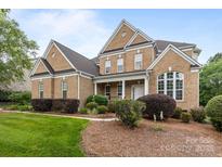 Charming two-story brick home with landscaped front yard, inviting entryway, and traditional architectural details at 561 Keystone Nw Ct, Concord, NC 28027