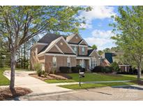 Charming brick two-story home featuring a well-manicured lawn, mature trees, and a classic design at 561 Keystone Nw Ct, Concord, NC 28027