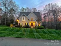 Charming brick home featuring a well-manicured lawn, a welcoming front door, and elegant architectural details at 821 Lynnwood Farms Dr, Fort Mill, SC 29715