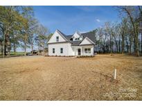 Charming white two-story home featuring black trim and roof situated on a spacious lot at 0000 Trull Hinson Rd # 1, Wingate, NC 28174