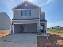 Two-story home featuring a grey exterior, open garage and professionally landscaped front yard at 102 Lightning Dr, Shelby, NC 28152