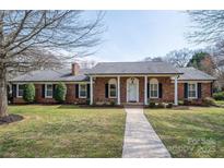 Charming brick home featuring a well-manicured lawn, inviting entryway, and classic architectural details at 104 N Hawthorne St, Mount Holly, NC 28120