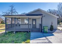 Charming single-story home with a covered porch, landscaped yard, and gray siding at 1104 Hudson St, Lancaster, SC 29720