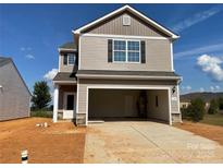 Two-story home boasts a large two-car garage, neutral siding, a covered porch, and an unfinished front yard at 119 Lightning Dr, Shelby, NC 28152