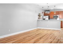 Bright kitchen with modern appliances and warm, wood-look laminate floors at 12417 Mcgrath Dr, Charlotte, NC 28269