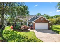 Charming one-story home featuring brick and siding with a two-car garage and beautiful landscaping at 1347 Eisenhower Nw Pl, Concord, NC 28027