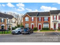 View of townhomes with red shutters, neat landscaping, and car parking at 1965 Charlotte Hwy # 401, Mooresville, NC 28115