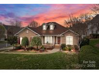Charming brick home featuring manicured lawn, dormer windows and inviting front porch at 20601 Belair Ct, Cornelius, NC 28031