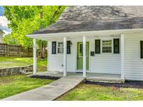 Charming home with a well-manicured lawn, covered front porch and a green front door at 210 Knox St, Clover, SC 29710