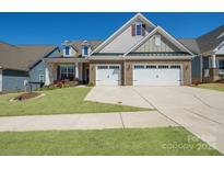 Beautiful brick and siding home showcasing a manicured lawn and a convenient two-car garage at 22014 Finworthy Ln, Huntersville, NC 28078