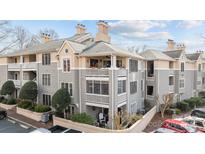 Attractive condo building with balconies, beige and gray colors, surrounded by green shrubs and trees at 226 Queens Rd # 73, Charlotte, NC 28204