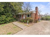Charming single-story brick home featuring a well-manicured lawn and a concrete driveway at 2922 Dunlavin Way, Charlotte, NC 28205